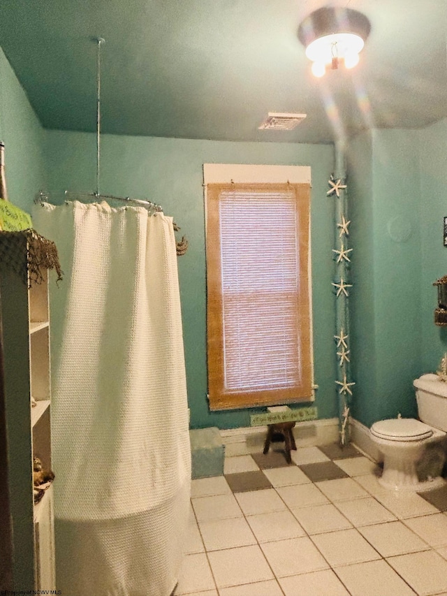 bathroom with tile patterned flooring and toilet