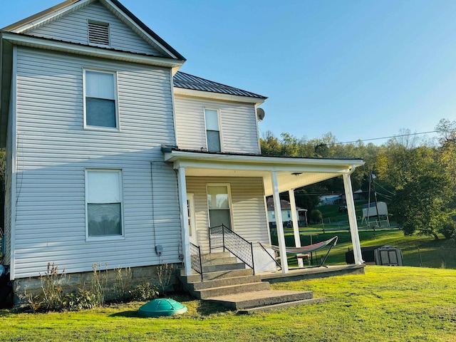 rear view of house featuring a lawn