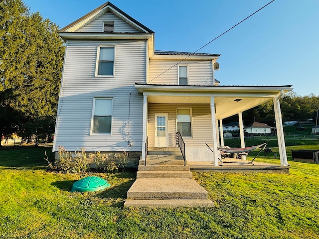 rear view of property featuring a lawn