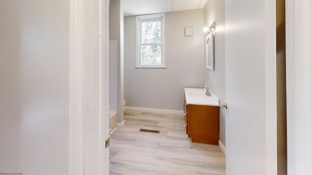 bathroom featuring a tub, hardwood / wood-style flooring, and vanity