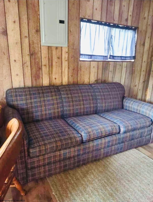 living area featuring wood walls and electric panel