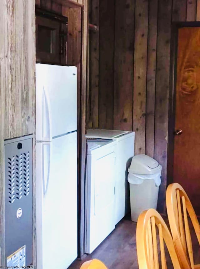 laundry area featuring wooden walls and washing machine and dryer