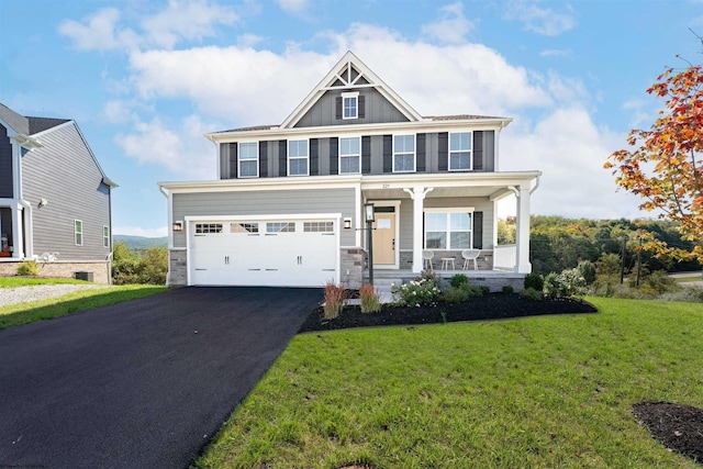 view of front facade featuring a garage, a front lawn, and covered porch