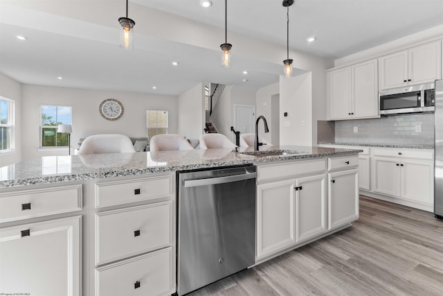 kitchen featuring light hardwood / wood-style floors, stainless steel appliances, sink, and white cabinets