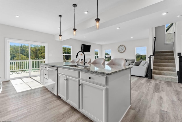 kitchen featuring an island with sink, white cabinetry, plenty of natural light, and sink