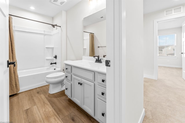 full bathroom featuring shower / tub combo with curtain, wood-type flooring, vanity, and toilet