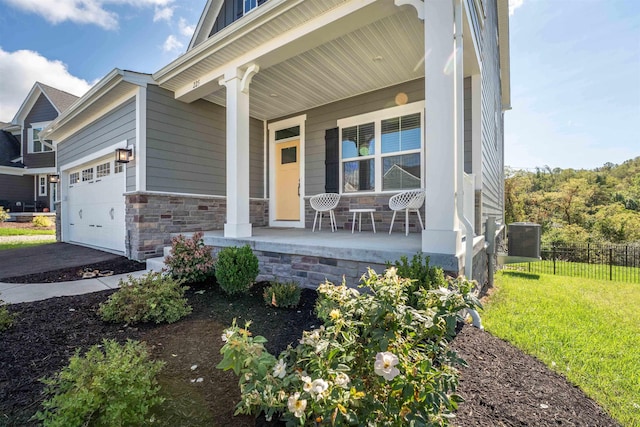 doorway to property with a lawn, a porch, and a garage