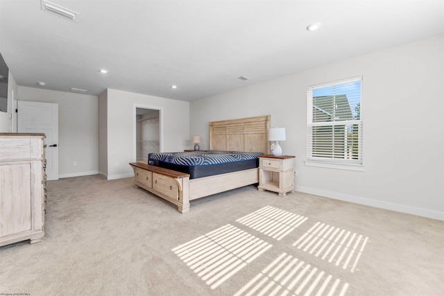 carpeted bedroom featuring a closet and a walk in closet