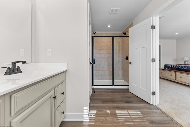 bathroom featuring walk in shower, vanity, and hardwood / wood-style floors