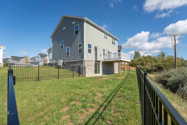 back of property featuring a lawn and a deck