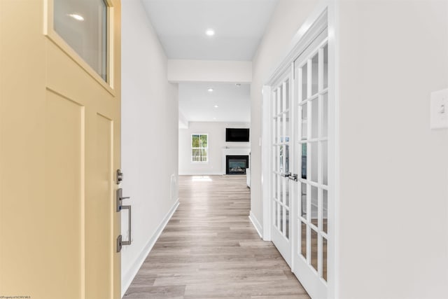 hallway featuring french doors and light hardwood / wood-style flooring