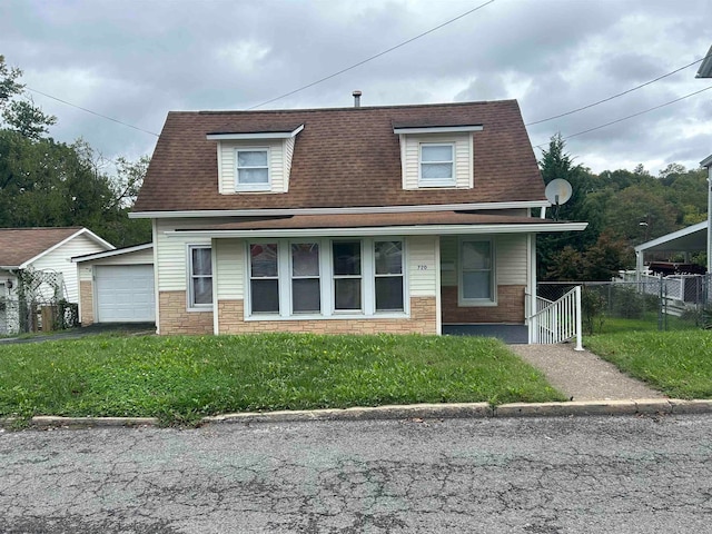 view of front facade featuring covered porch, a front yard, and a garage