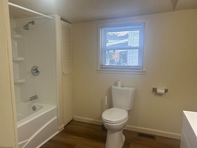 full bathroom featuring a textured ceiling, shower / bath combination, hardwood / wood-style floors, vanity, and toilet