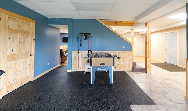 recreation room featuring a drop ceiling and tile patterned flooring