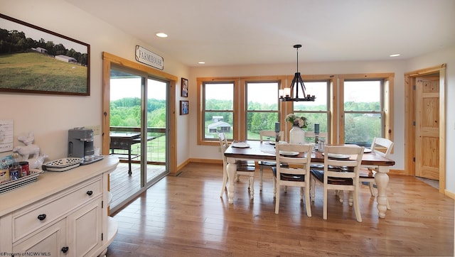 dining area featuring an inviting chandelier and light hardwood / wood-style flooring