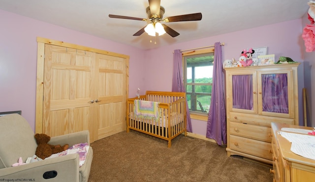 carpeted bedroom featuring a crib and ceiling fan