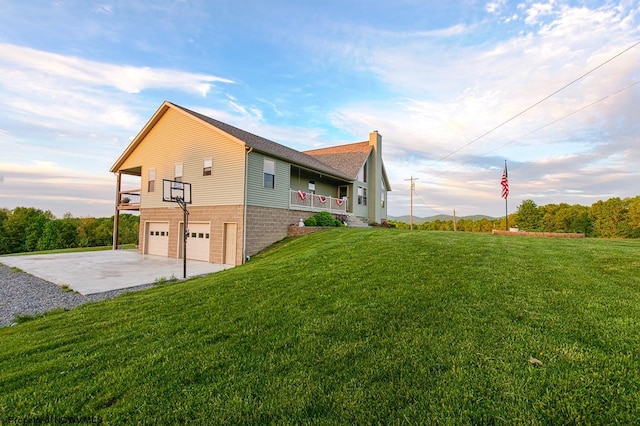 view of side of property with a garage and a lawn