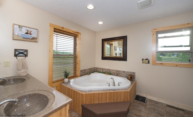 bathroom featuring vanity, a bath, and tile patterned floors