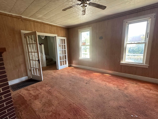 spare room with ceiling fan, wood walls, carpet, and wooden ceiling