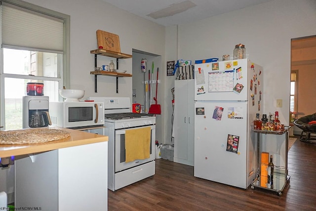 kitchen featuring white appliances and dark hardwood / wood-style floors