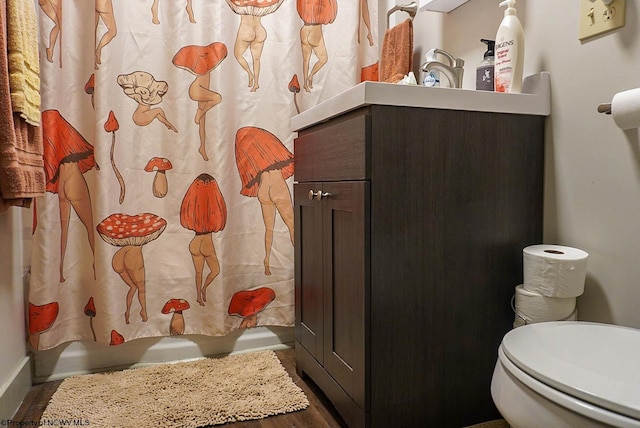 bathroom with wood-type flooring, vanity, and toilet