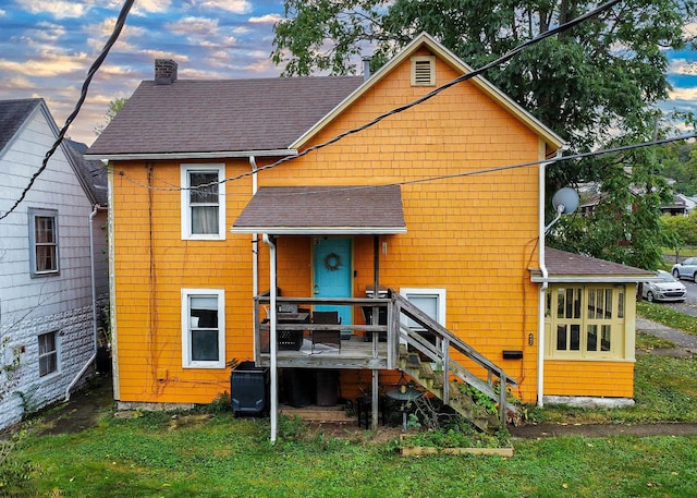 back house at dusk featuring a yard