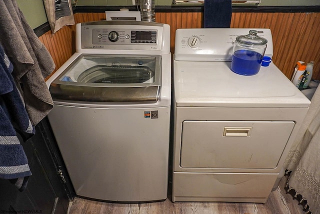 clothes washing area with washer and dryer and wood-type flooring