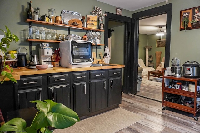 bar with light wood-type flooring and butcher block counters