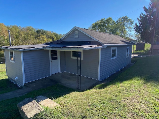 back of property with a lawn and a patio area