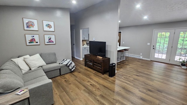 living room with lofted ceiling, baseboard heating, and hardwood / wood-style flooring