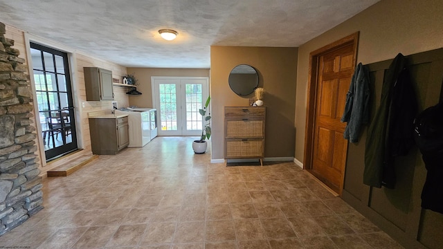 interior space featuring french doors, washer / clothes dryer, and a textured ceiling