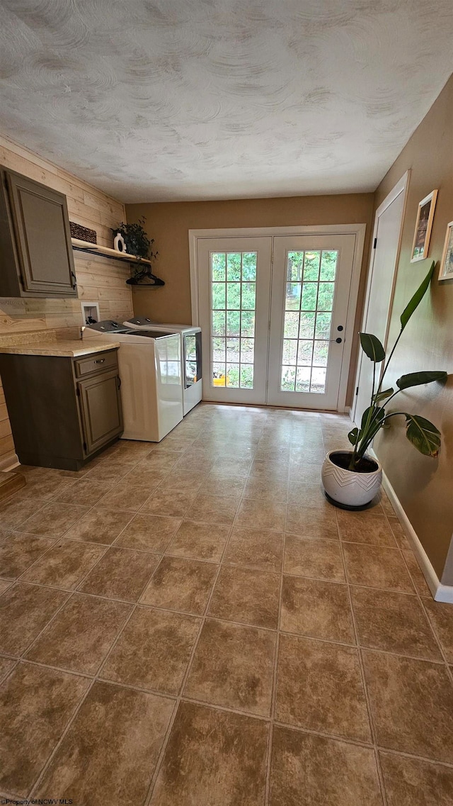 kitchen featuring washer and clothes dryer, dark tile patterned flooring, dark brown cabinets, french doors, and a textured ceiling