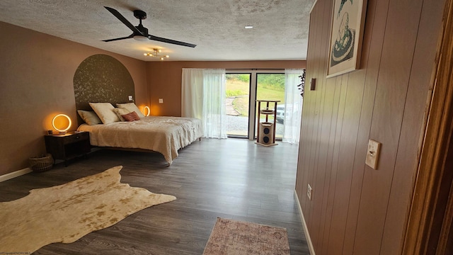 bedroom featuring access to outside, a textured ceiling, dark hardwood / wood-style floors, and ceiling fan