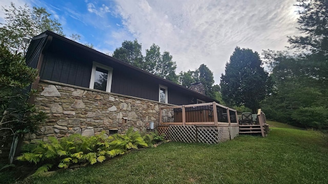 back of property featuring a deck and a yard