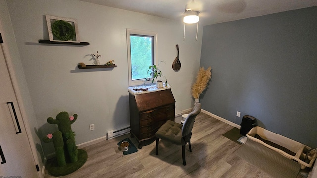 interior space with ceiling fan, hardwood / wood-style flooring, and baseboard heating