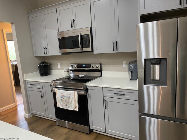 kitchen featuring gray cabinetry, dark wood-type flooring, and stainless steel appliances