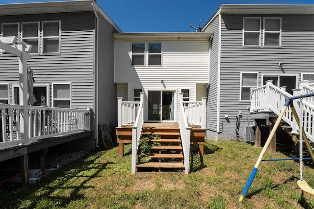 rear view of house with a lawn and a wooden deck