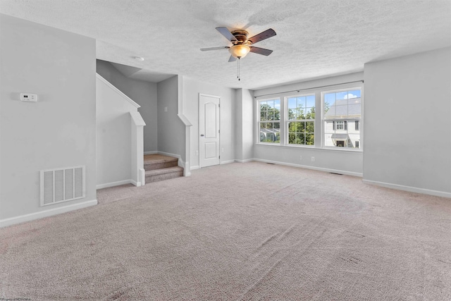 unfurnished living room featuring ceiling fan, a textured ceiling, and light carpet