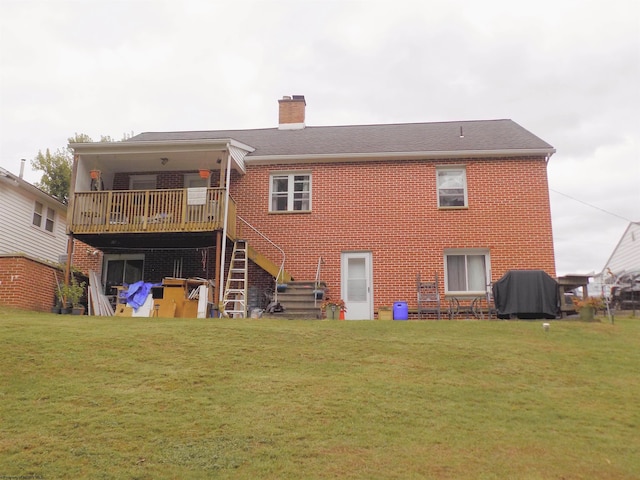 rear view of house featuring a wooden deck and a lawn