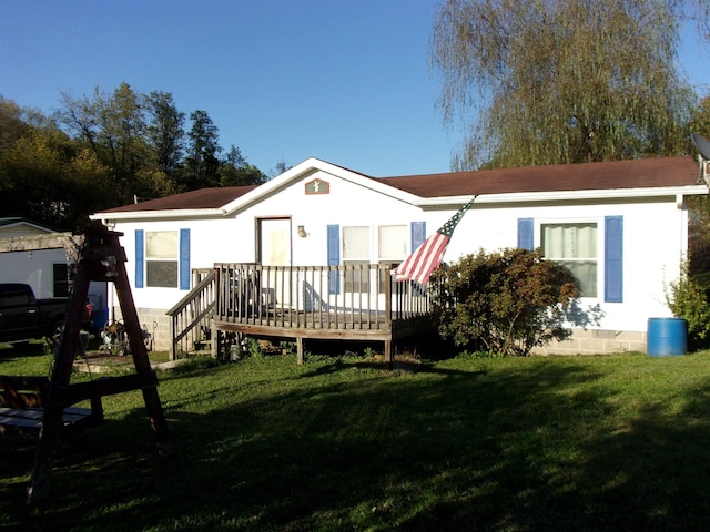 back of house featuring a deck and a lawn