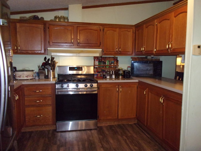 kitchen with crown molding, vaulted ceiling, stainless steel appliances, and dark hardwood / wood-style flooring