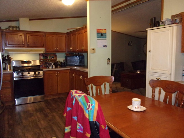 kitchen with a textured ceiling, dark hardwood / wood-style flooring, lofted ceiling, stainless steel range, and ornamental molding