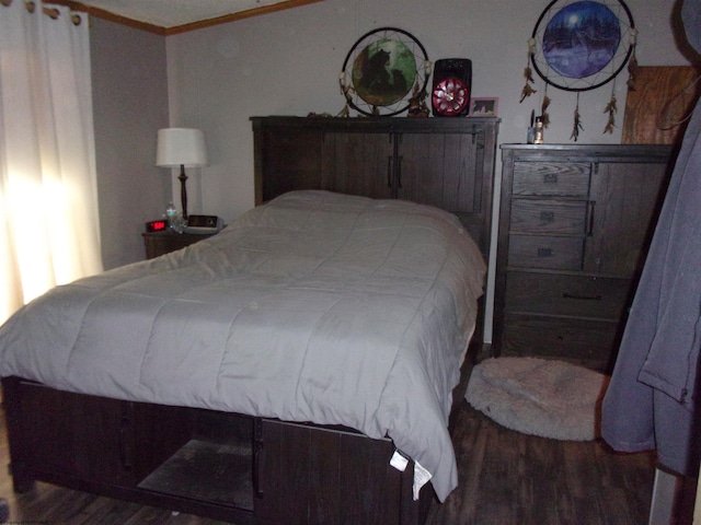 bedroom with crown molding and dark hardwood / wood-style flooring