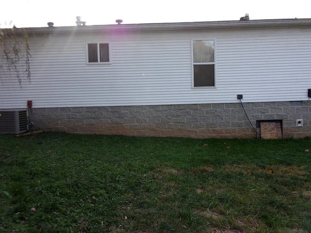 view of side of home featuring a yard and central AC unit