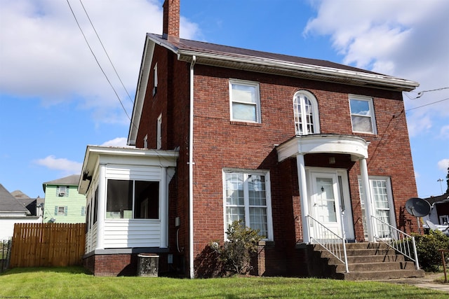 view of front of property featuring a front lawn and central AC unit