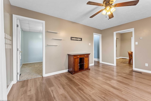 unfurnished living room with light wood-type flooring and ceiling fan