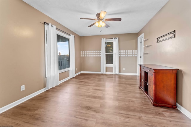 empty room featuring light wood-type flooring and ceiling fan