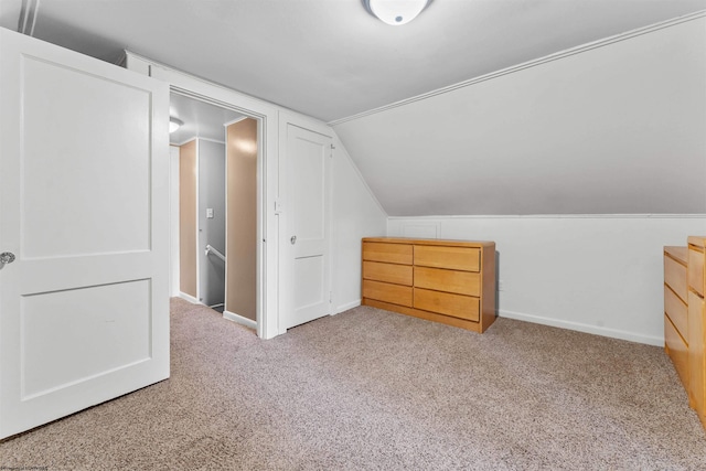 additional living space featuring light colored carpet and vaulted ceiling