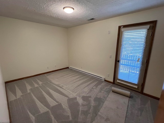 empty room featuring carpet floors, a baseboard heating unit, and a textured ceiling