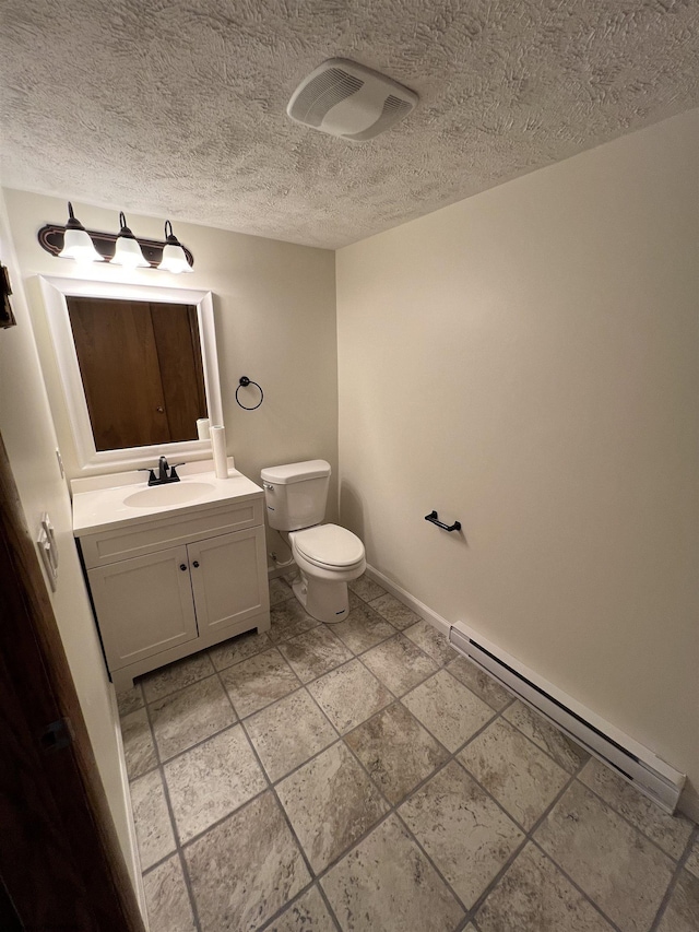 half bath with toilet, vanity, a baseboard heating unit, baseboards, and a textured ceiling